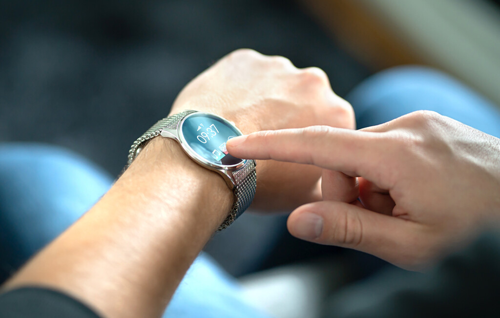 Person, die eine Smartwatch bedient, die mit kompakter System-in-Package (SiP)-Technologie betrieben wird, die fortschrittliche Funktionen und eine lange Batterielebensdauer in tragbaren Geräten ermöglicht.